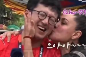 热情女球迷🤣韩国一记者在墨西哥报道世界杯，被球迷搂住亲脸颊配图